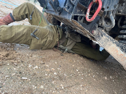 מכונאי מתחת לרכב שהוא מתקן